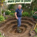 Un jardin avec un étang à faune, entouré de fleurs et de verdure.